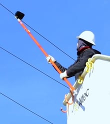 Line Worker Using A Voltage Detector Meter